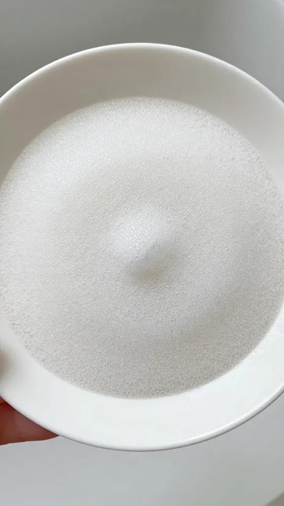 soap-sudsed melamine plate rim under faucet, freeze-frame