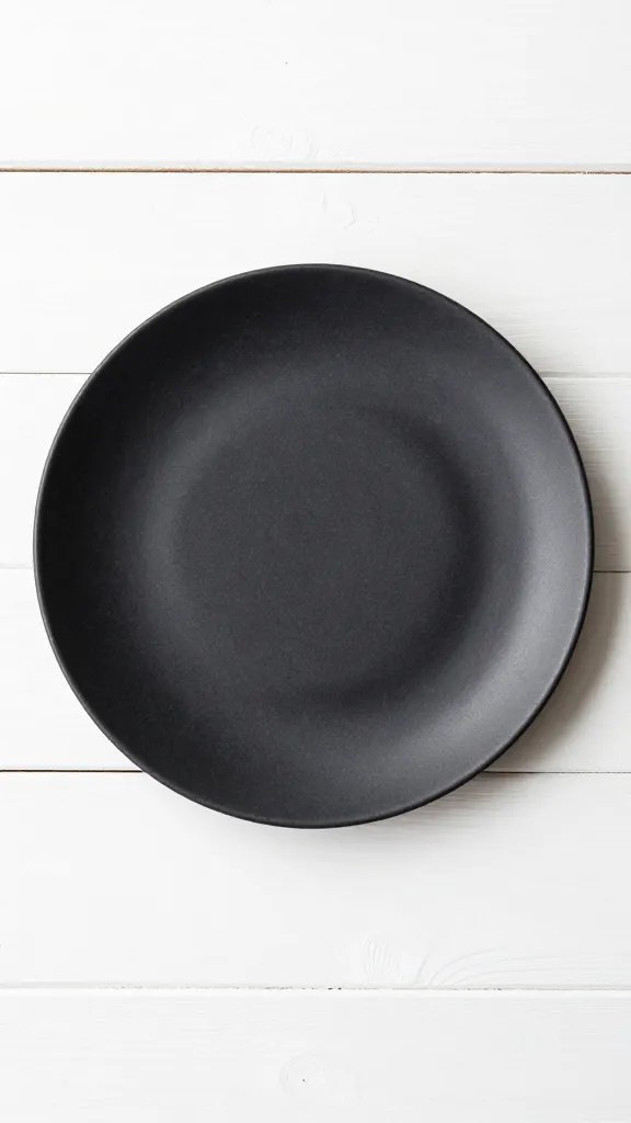 single black stoneware plate on white oak slat surface