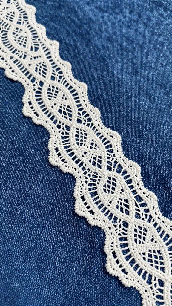closeup lace doily over denim picnic blanket