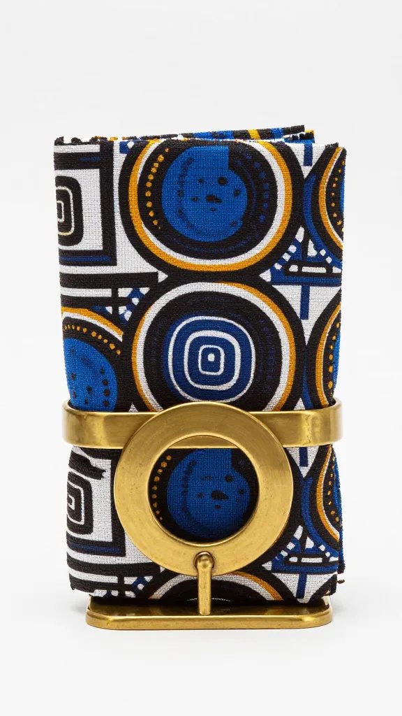single Adire napkin ringed with brass holder