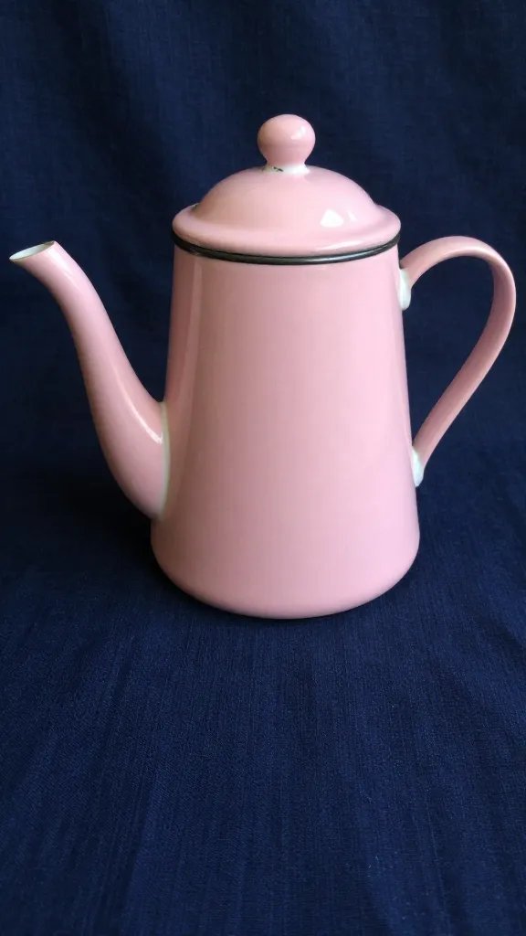 vintage pink enamel teapot on dark blue cloth