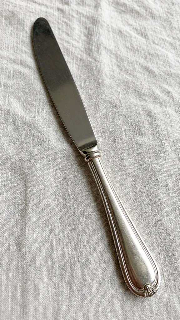 Vintage silver butter knife on linen runner