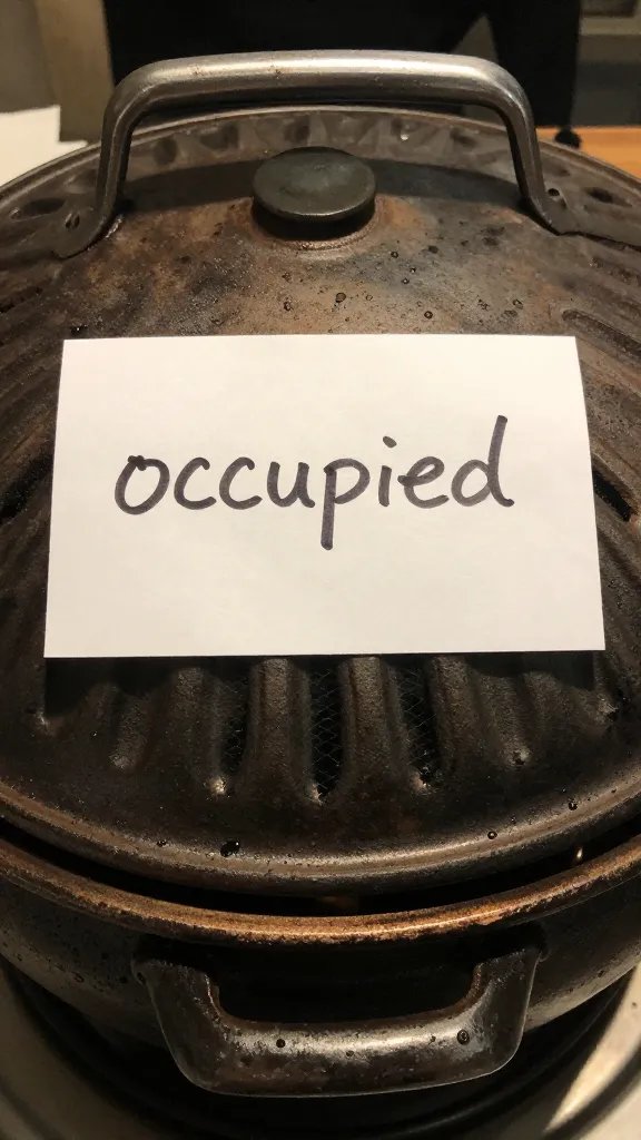 handwritten “occupied” note taped to grill lid