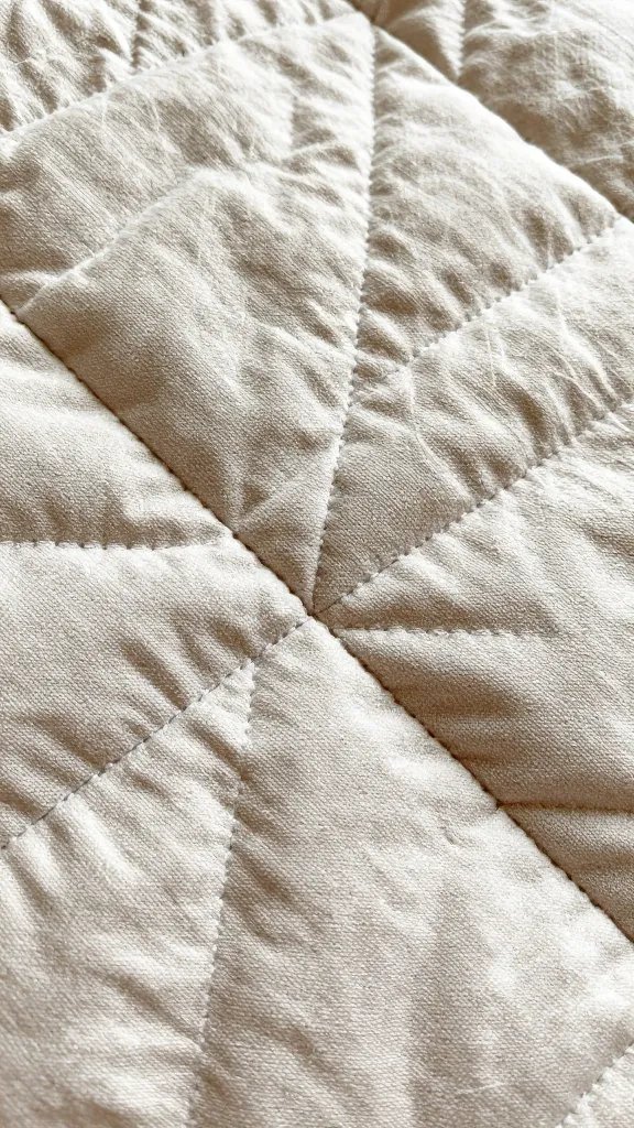 quilted picnic blanket stitching macro, earthy tones