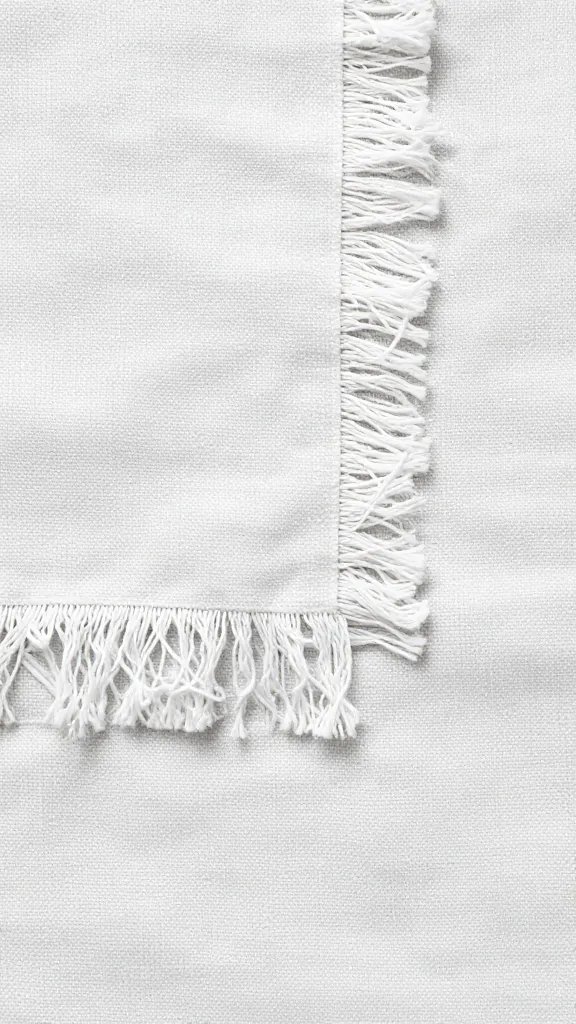 Corner of picnic blanket with frayed, abraded threads