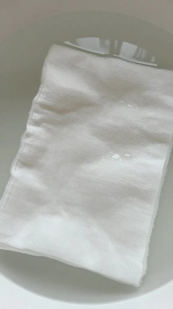 closeup of undyed cotton napkin soaking in alum bath