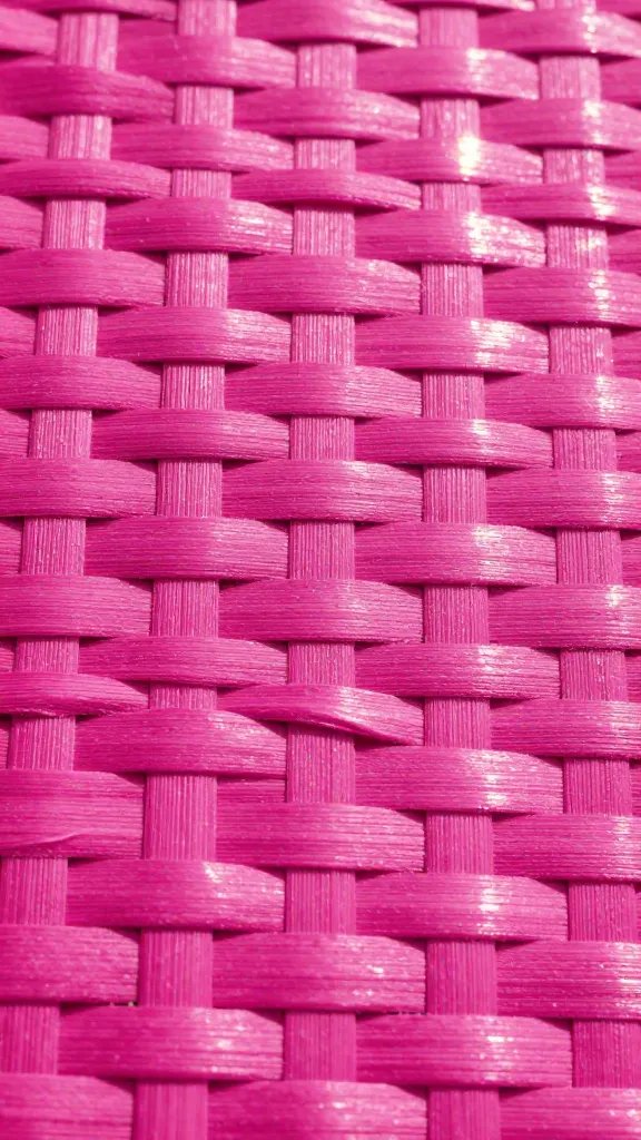 Closeup of fuchsia pink woven basket surface with sunlight glow