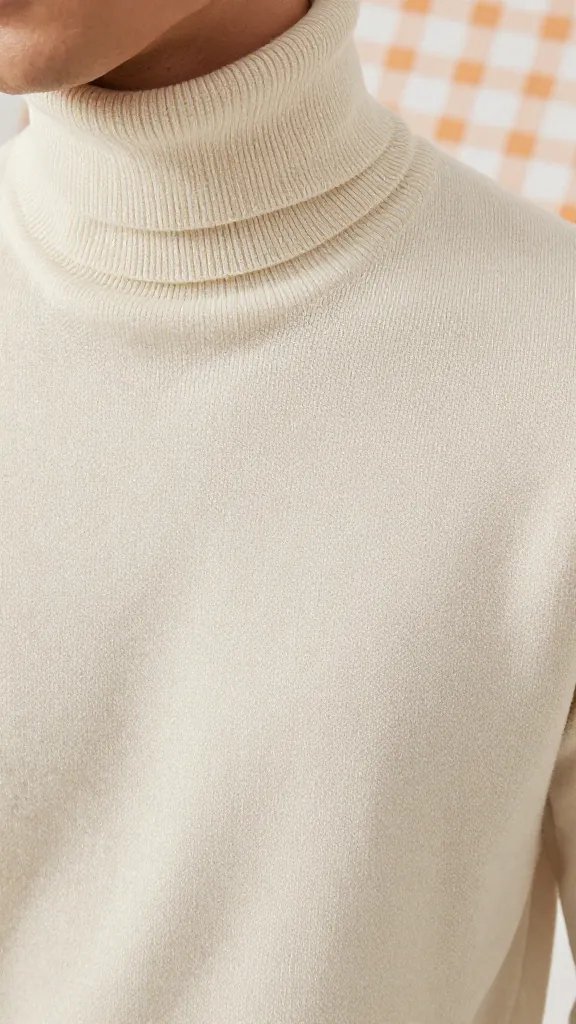 closeup of individual in cream turtleneck beside picnic blanket texture