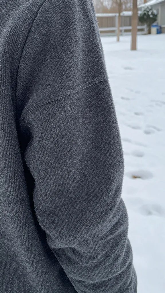 closeup of person wearing layered textures vs snowy lawn backdrop